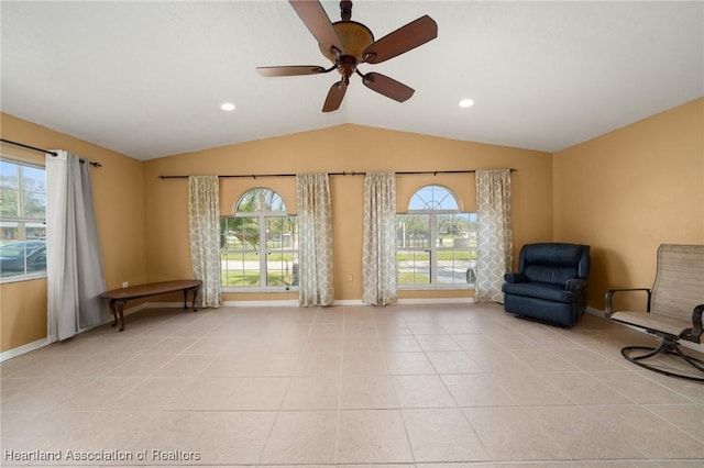 unfurnished room featuring ceiling fan, light tile patterned floors, and vaulted ceiling