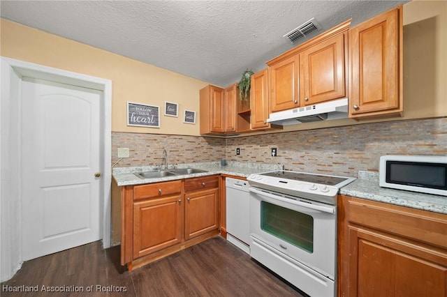 kitchen with a textured ceiling, backsplash, sink, and white appliances