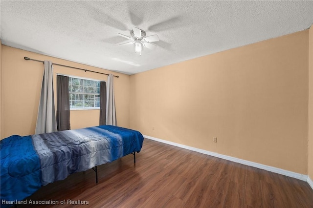 bedroom featuring a textured ceiling, dark hardwood / wood-style floors, and ceiling fan