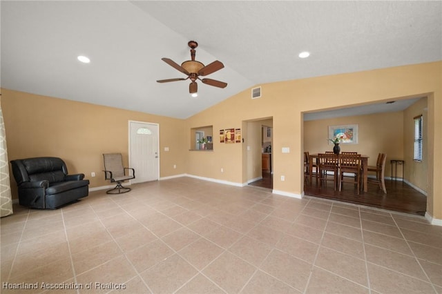 interior space with light tile patterned floors, vaulted ceiling, and ceiling fan