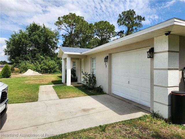 exterior space with an attached garage, stucco siding, and a lawn