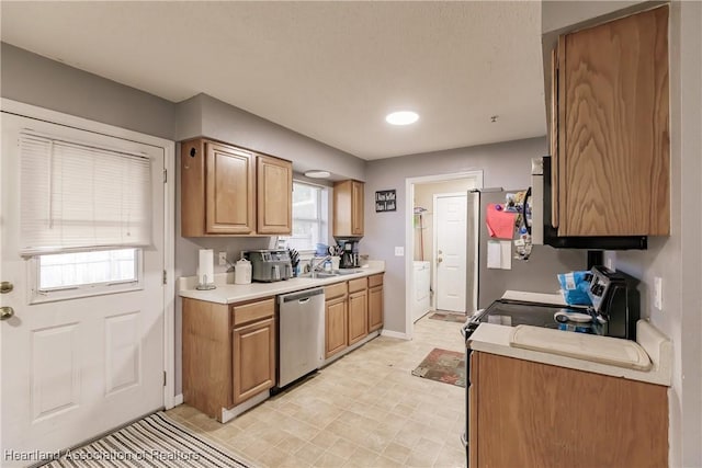 kitchen with stainless steel dishwasher, electric stove, sink, and washer / clothes dryer