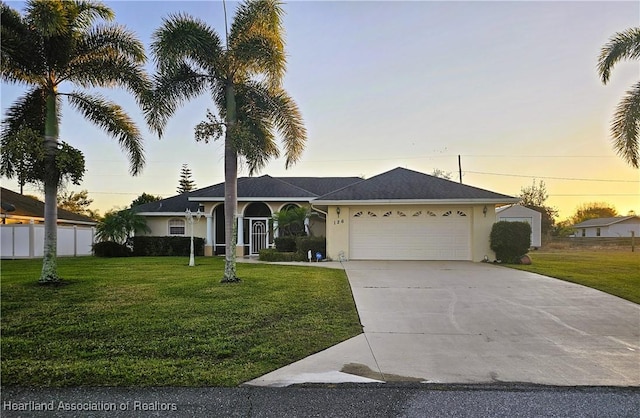 ranch-style house with a garage and a yard