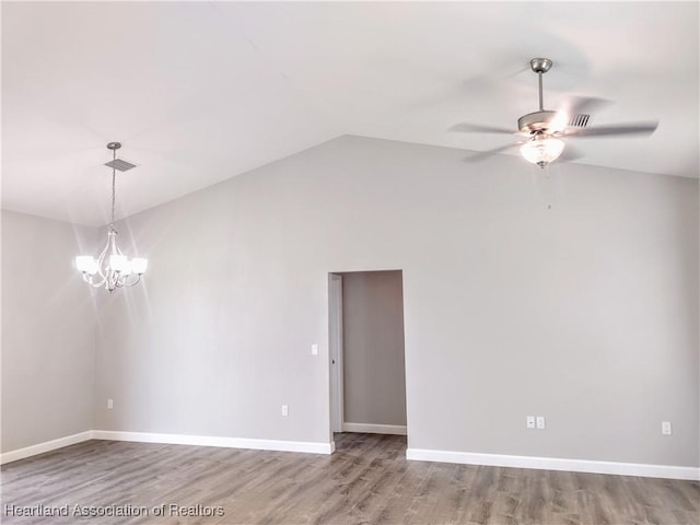 unfurnished room with hardwood / wood-style floors, ceiling fan with notable chandelier, and vaulted ceiling