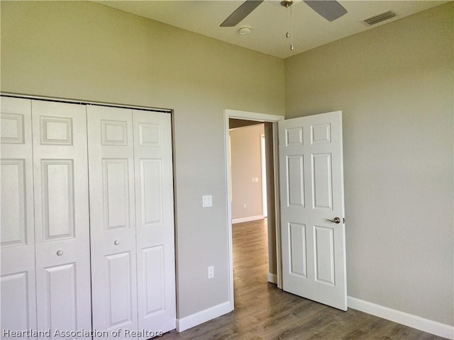 unfurnished bedroom featuring ceiling fan, a closet, and wood-type flooring