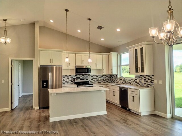 kitchen featuring appliances with stainless steel finishes, sink, white cabinets, a kitchen island, and hanging light fixtures