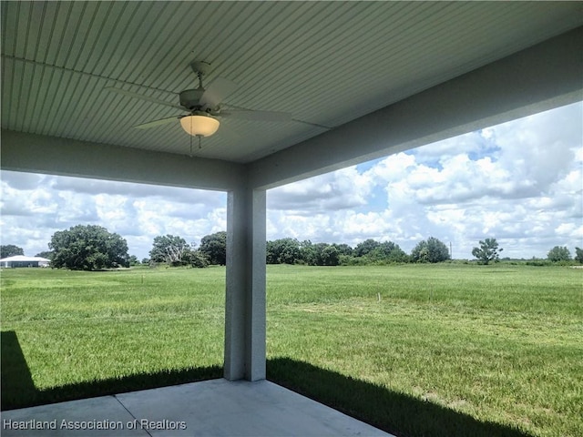 view of yard featuring ceiling fan, a rural view, and a patio