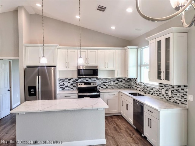 kitchen featuring white cabinets, appliances with stainless steel finishes, a center island, and sink