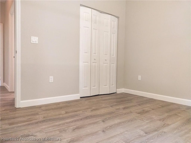 unfurnished bedroom featuring a closet and light wood-type flooring