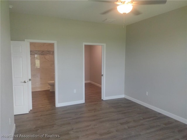 unfurnished bedroom featuring a walk in closet, ceiling fan, dark hardwood / wood-style floors, connected bathroom, and a closet