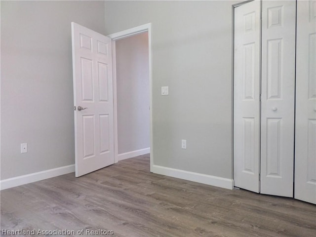 unfurnished bedroom with light hardwood / wood-style floors and a closet