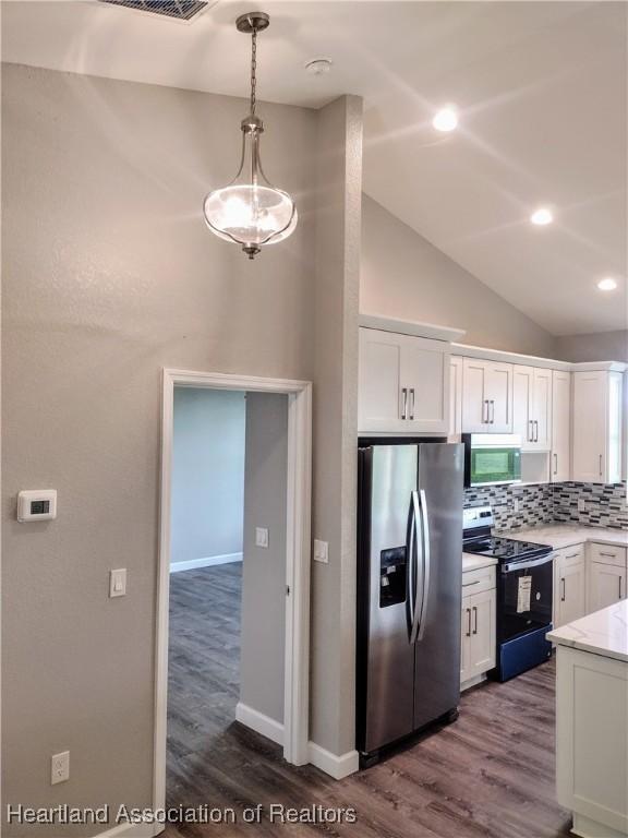 kitchen with decorative backsplash, stainless steel refrigerator with ice dispenser, white cabinets, black range with electric stovetop, and hanging light fixtures