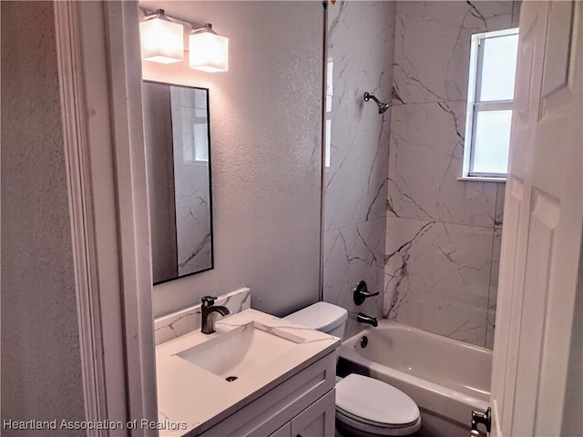 full bathroom with vanity, tiled shower / bath combo, and toilet