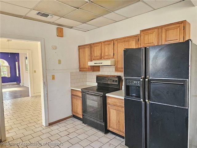 1237 Hitakee Ave, Sebring, FL 33870 - kitchen with black appliances, under cabinet range hood, light countertops, a drop ceiling, and baseboards