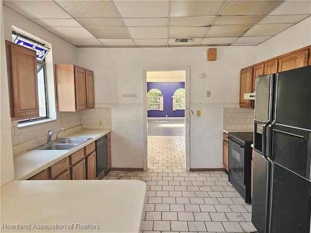 1237 Hitakee Ave, Sebring, FL 33870 - kitchen featuring black appliances, a sink, light countertops, a paneled ceiling, and brown cabinets