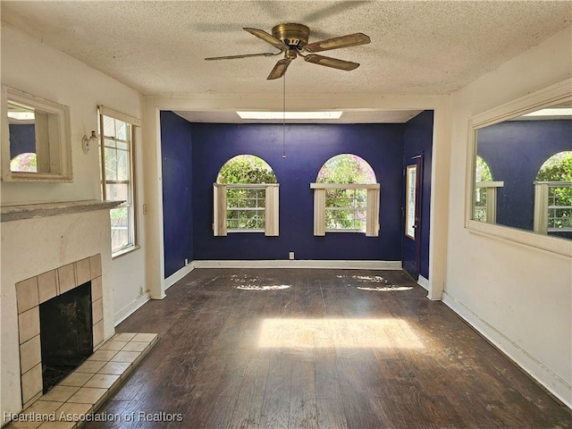 1237 Hitakee Ave, Sebring, FL 33870 - unfurnished living room featuring a ceiling fan, wood finished floors, plenty of natural light, a textured ceiling, and a fireplace