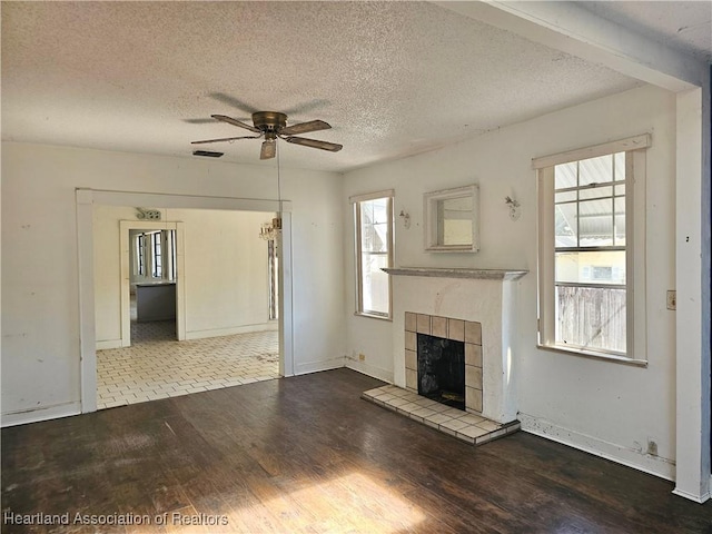 1237 Hitakee Ave, Sebring, FL 33870 - unfurnished living room with a ceiling fan, wood finished floors, a fireplace, healthy amount of natural light, and a textured ceiling
