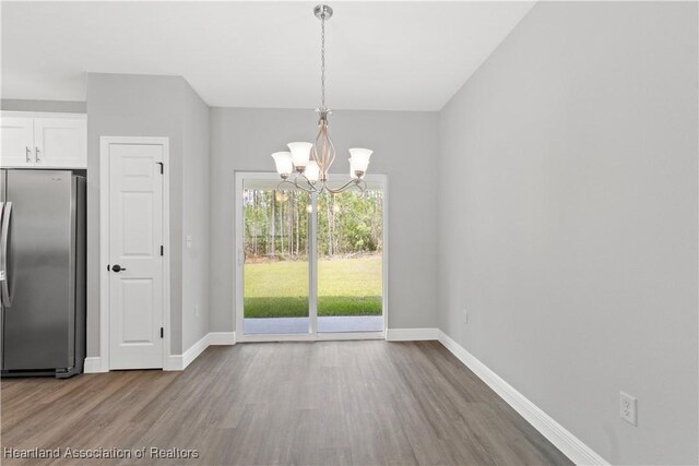 unfurnished dining area with light hardwood / wood-style flooring and a chandelier