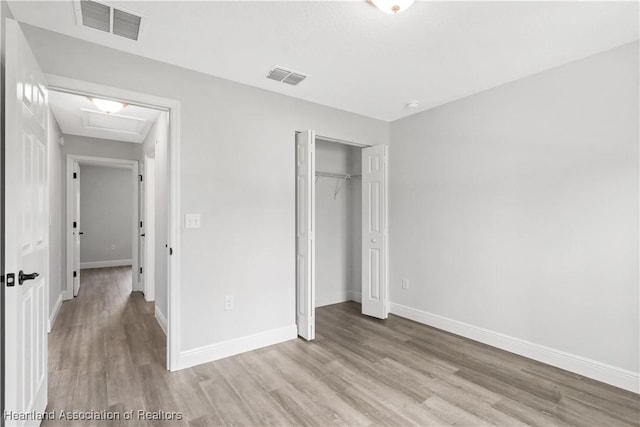 unfurnished bedroom featuring a closet and light hardwood / wood-style floors