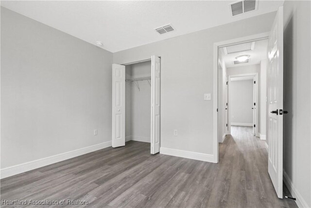 unfurnished bedroom with a closet and hardwood / wood-style floors