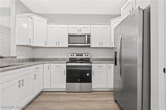 kitchen featuring white cabinets, light stone counters, sink, and stainless steel appliances