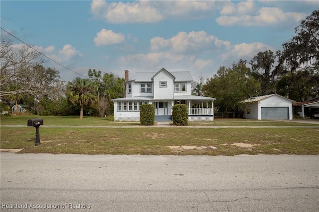 view of front of home featuring covered porch, a front lawn, an outdoor structure, and a garage