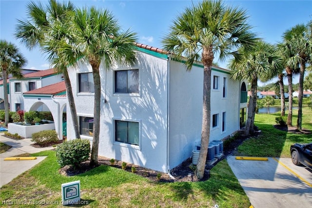 view of property exterior with a yard and central air condition unit