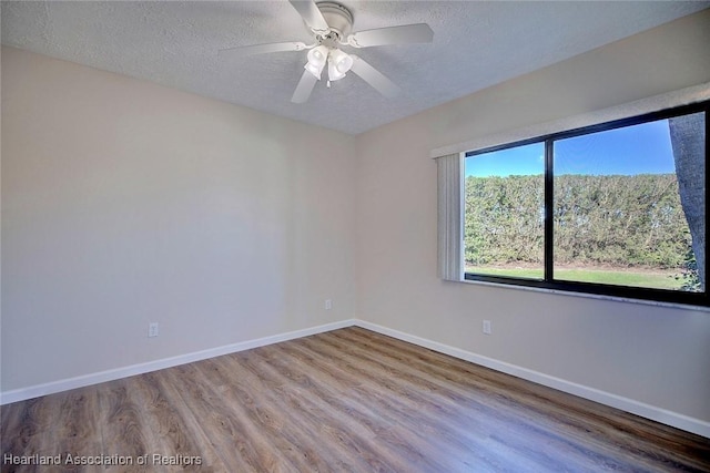 unfurnished room with ceiling fan, hardwood / wood-style floors, and a textured ceiling