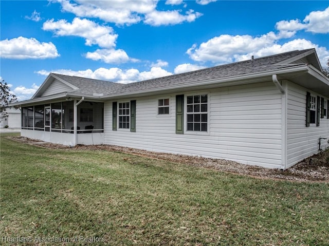 back of property with a yard and a sunroom