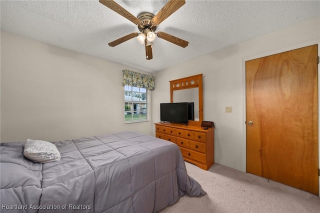 bedroom with carpet flooring, ceiling fan, and a textured ceiling