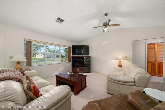 carpeted living room with ceiling fan and lofted ceiling