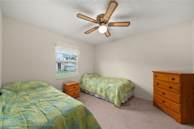 bedroom featuring ceiling fan, carpet, and a textured ceiling