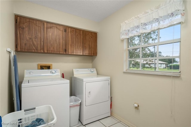 laundry area featuring cabinets, independent washer and dryer, a textured ceiling, and light tile patterned floors