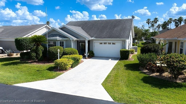 view of front of property featuring a front yard, an attached garage, and concrete driveway