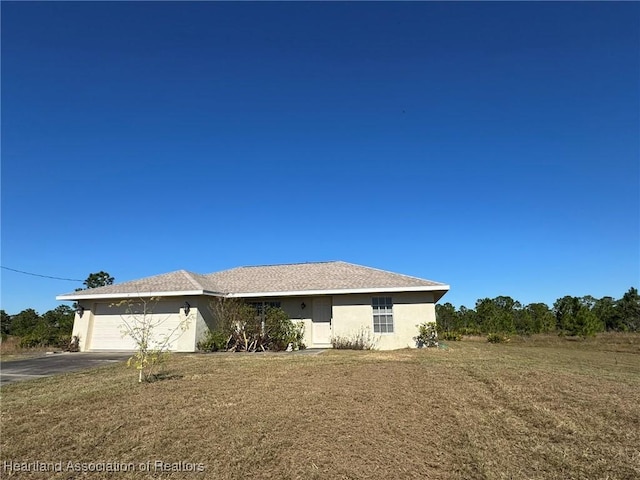 single story home featuring a garage and a front yard