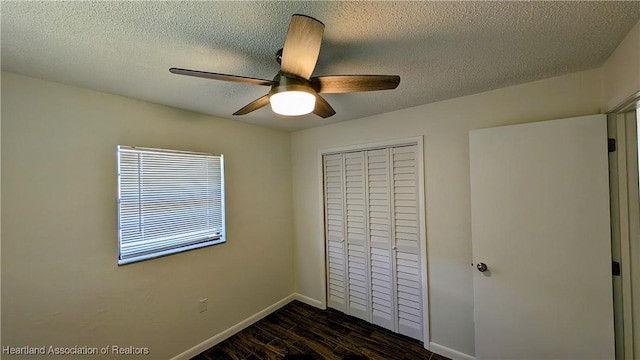 unfurnished bedroom featuring a textured ceiling, a closet, ceiling fan, and dark hardwood / wood-style floors