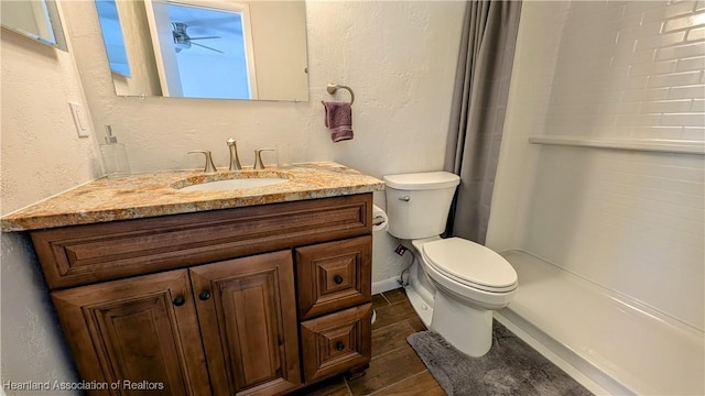 bathroom with tile patterned floors, vanity, toilet, and a shower