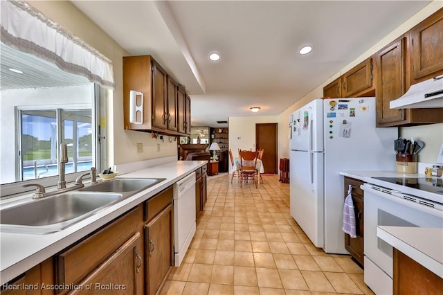 7700 Granada Rd, Sebring, FL 33876 - kitchen with under cabinet range hood, white appliances, light countertops, and a sink