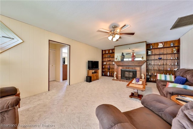 7700 Granada Rd, Sebring, FL 33876 - living area with a fireplace, carpet, a ceiling fan, visible vents, and built in shelves