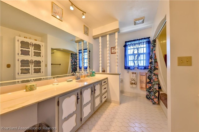 7700 Granada Rd, Sebring, FL 33876 - bathroom featuring track lighting, baseboards, a shower with shower curtain, vanity, and tile patterned flooring
