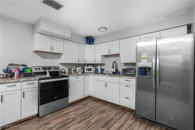 kitchen with sink, dark hardwood / wood-style floors, light stone countertops, appliances with stainless steel finishes, and white cabinetry