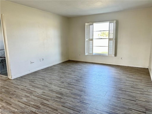 empty room with baseboards and wood finished floors