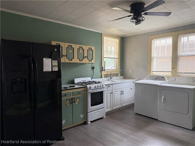 351 N Commerce Ave, Sebring, FL 33870 - kitchen with black refrigerator with ice dispenser, white gas range, a sink, ceiling fan, and washing machine and dryer