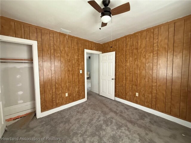 351 N Commerce Ave, Sebring, FL 33870 - unfurnished bedroom featuring wood walls, carpet, a closet, and a ceiling fan