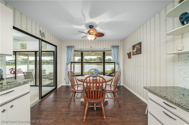 2407 Par Rd, Sebring, FL 33872 - dining area with dark wood-type flooring, wallpapered walls, a ceiling fan, and baseboards