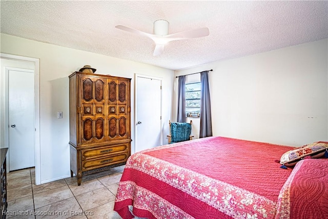 bedroom with ceiling fan, a textured ceiling, and light tile patterned floors