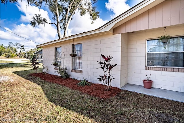 view of side of home with a yard