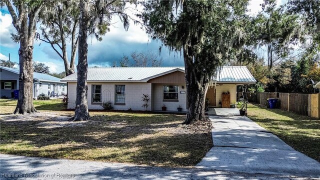 ranch-style home with a carport and a front yard