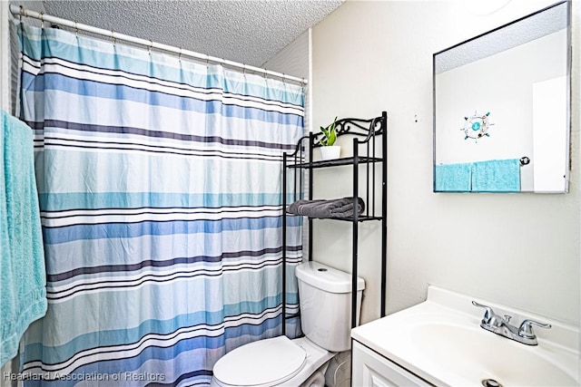 bathroom featuring vanity, a shower with curtain, toilet, and a textured ceiling