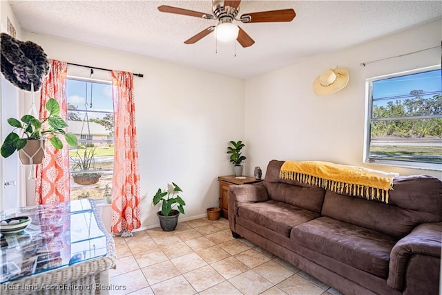 tiled living room with ceiling fan and a textured ceiling